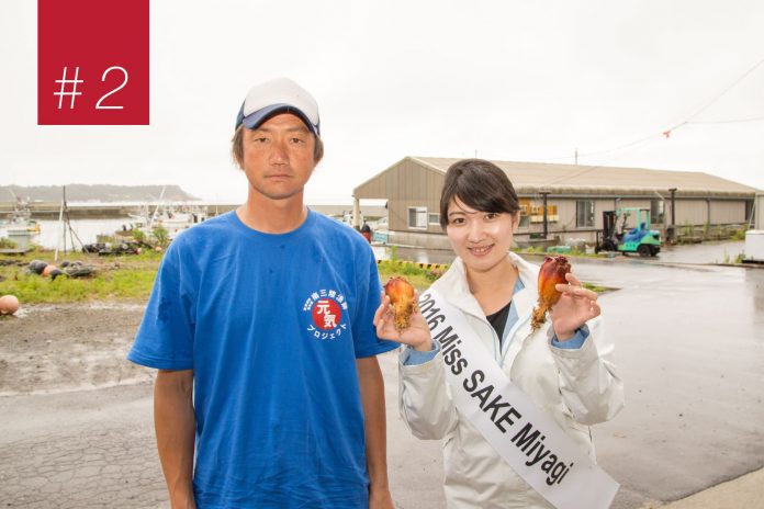 港近くで青いTシャツの男性と2016 Miss SAKE Miyagiのたすきをかけた女性が並び、ホヤを手に笑顔を見せている写真の左上に赤い背景に「＃2」と書かれた四角形がある画像