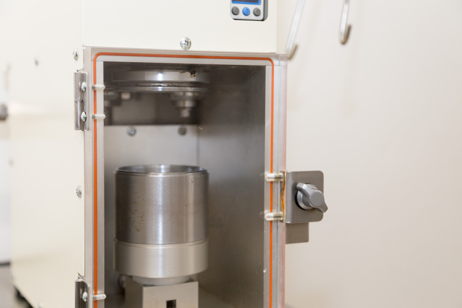 白い箱型の機械で、中に銀色の圧縮装置が入っている機械の写真