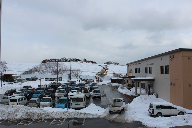 庁舎前の駐車場に多くの車が停まっており、周辺一帯が雪に覆われいる大雪の様子を写した写真