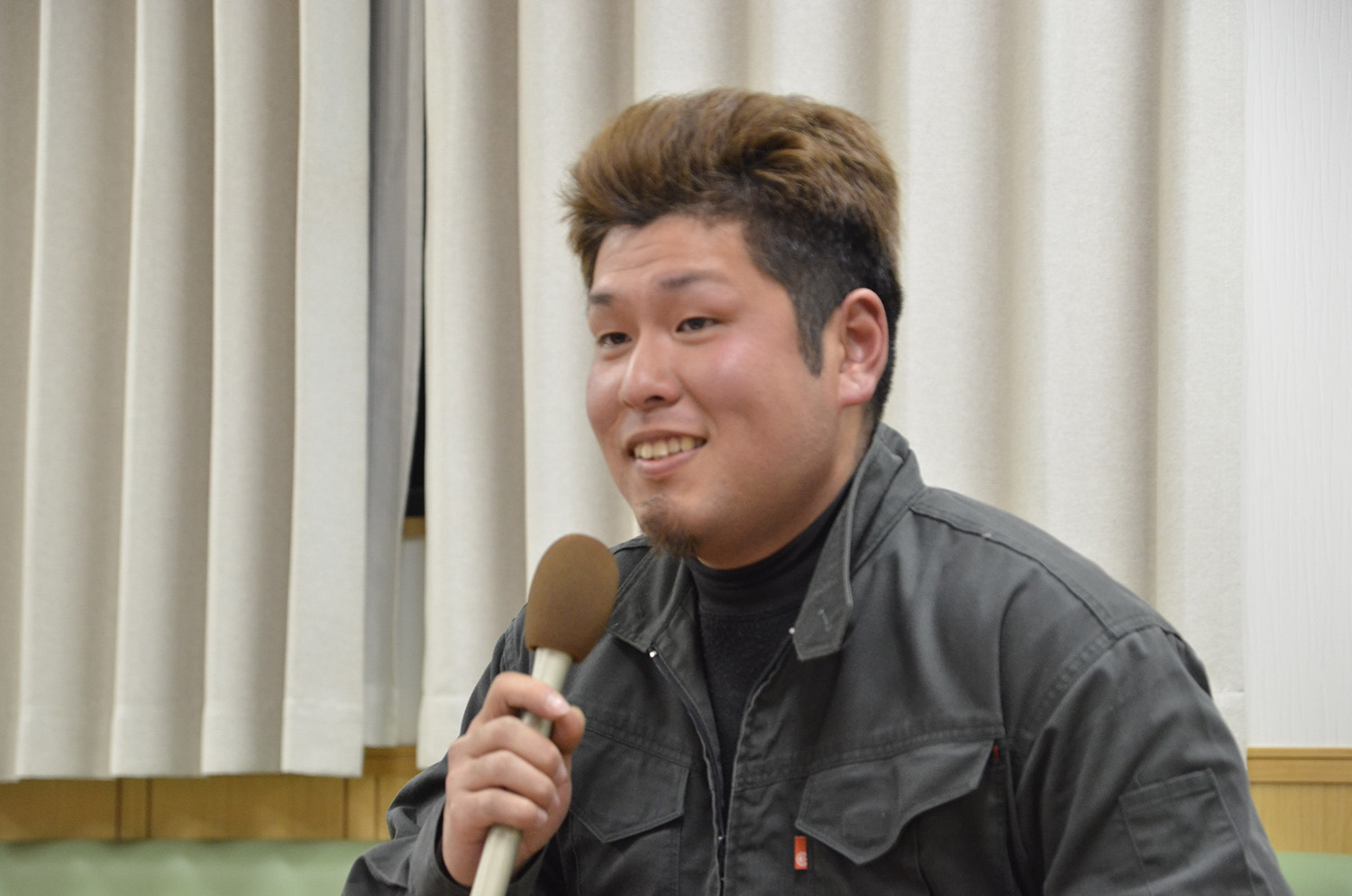 マイクを持ってインタビューに答える千葉さんの写真