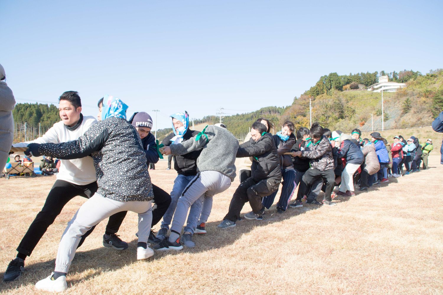 参加者が真剣な表情で綱引きを行っている様子の写真
