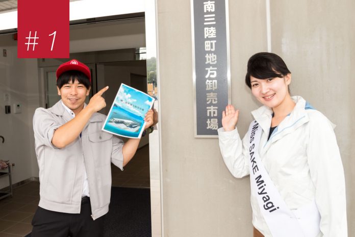 南三陸町地方卸売市場の看板の横で、赤い帽子をかぶってパンフレットを持った男性と、ミス日本酒のタスキをかけた池田かほりさんが看板を手で示して案内している写真の左上に赤い背景に「＃1」と書かれた四角形がある画像