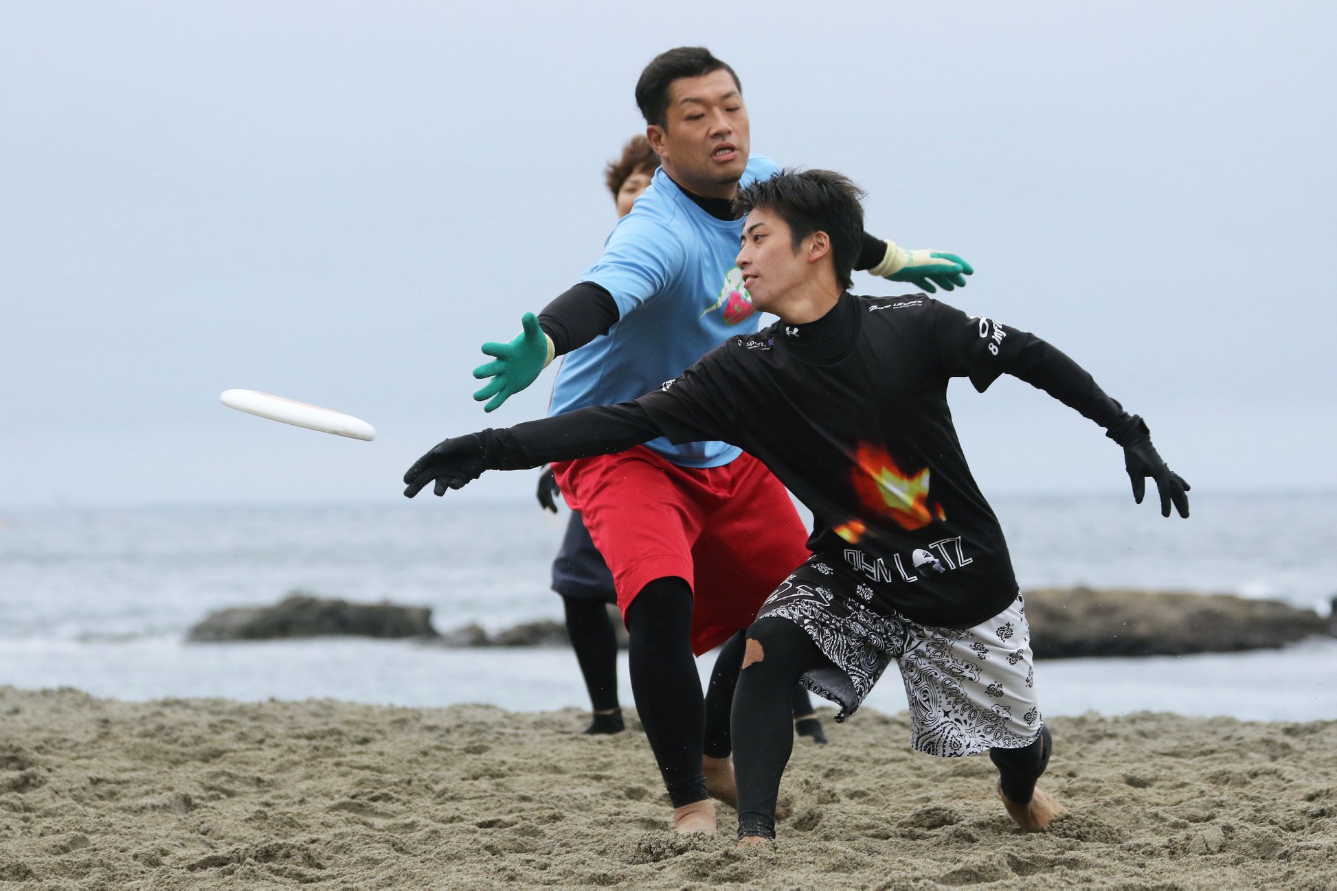 選手が仲間に向かって投げるのを相手のディフェンスが必死にカットしようとする様子の写真