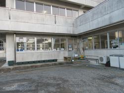 コンクリート造の建物の一角にある、窓越しに室内の様子が見える志津川地区放課後児童クラブの外観写真