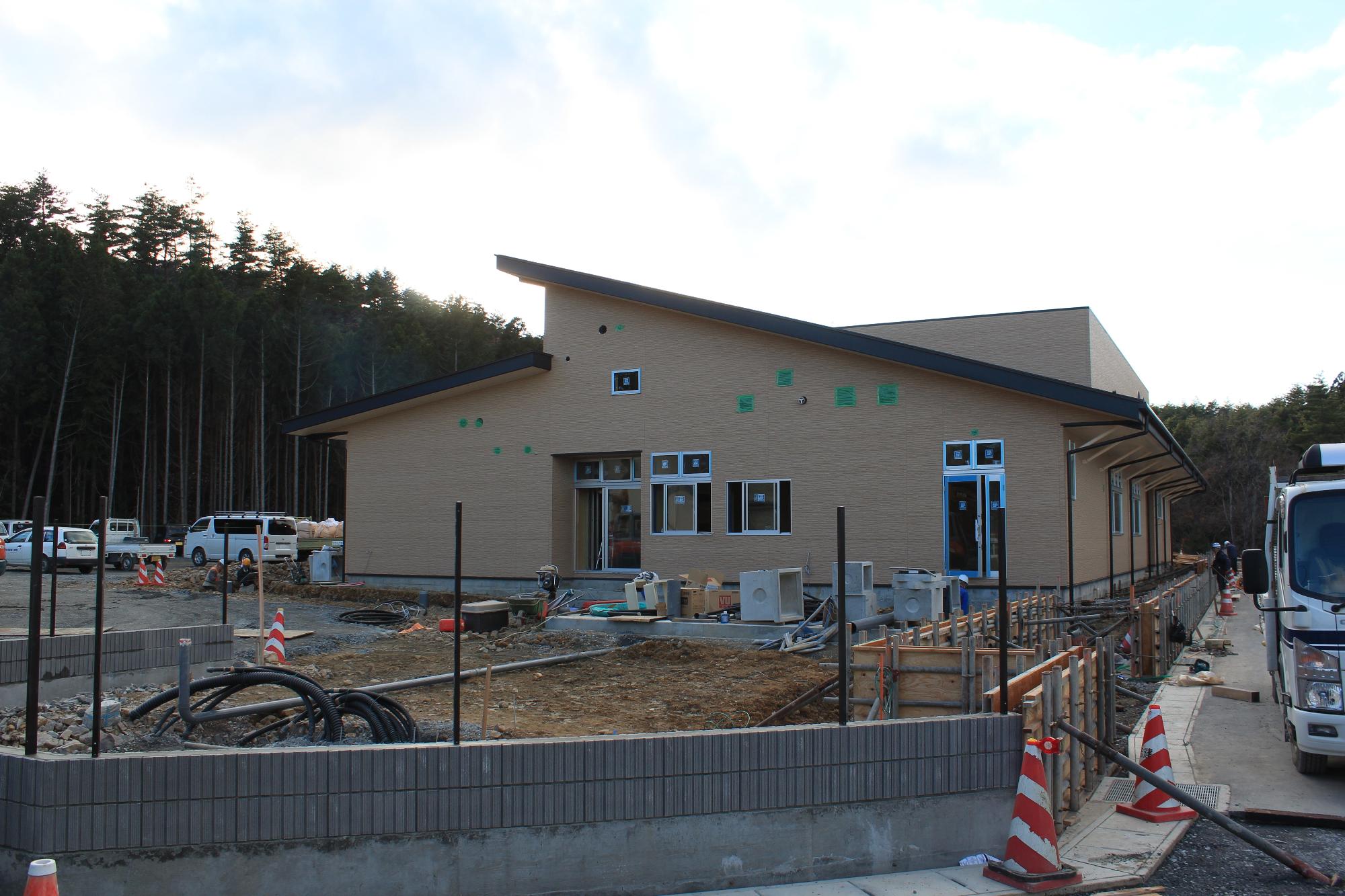 足場と防塵用の白いシートが外され戸倉地区子育て支援拠点施設の外観が現れた写真