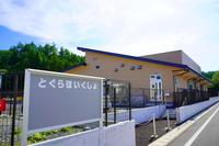 「とぐらほいくしょ」と書かれた看板が設置された、保育園入口付近の外観写真