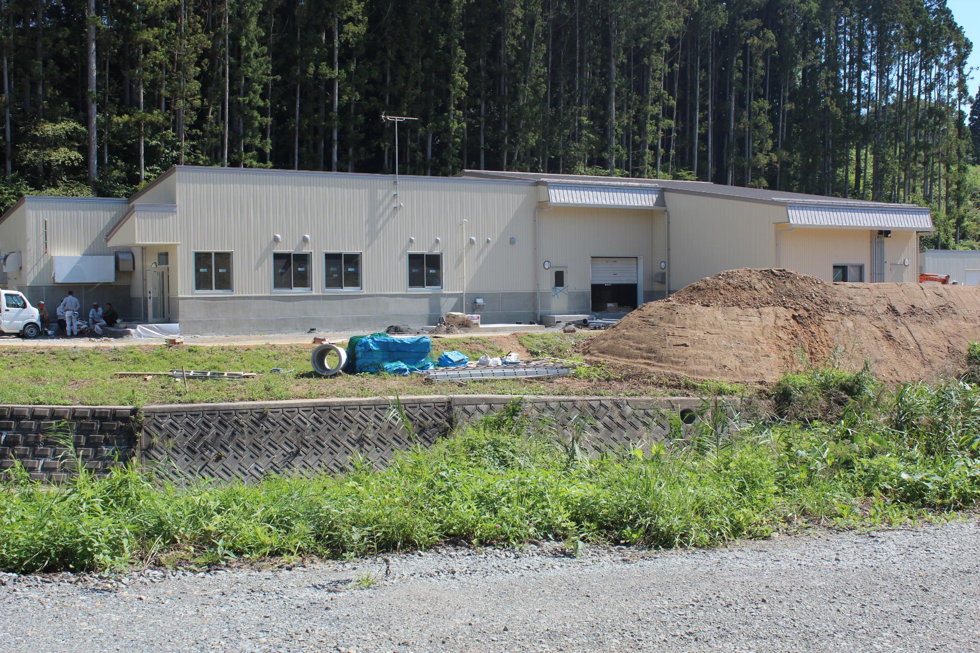 建物の前には土砂が積まれており、進行中の外構工事を撮影した写真