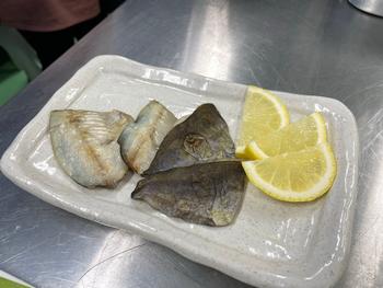 白い皿に魚のひれのような食材とレモンのくし切りが盛り付けられている写真
