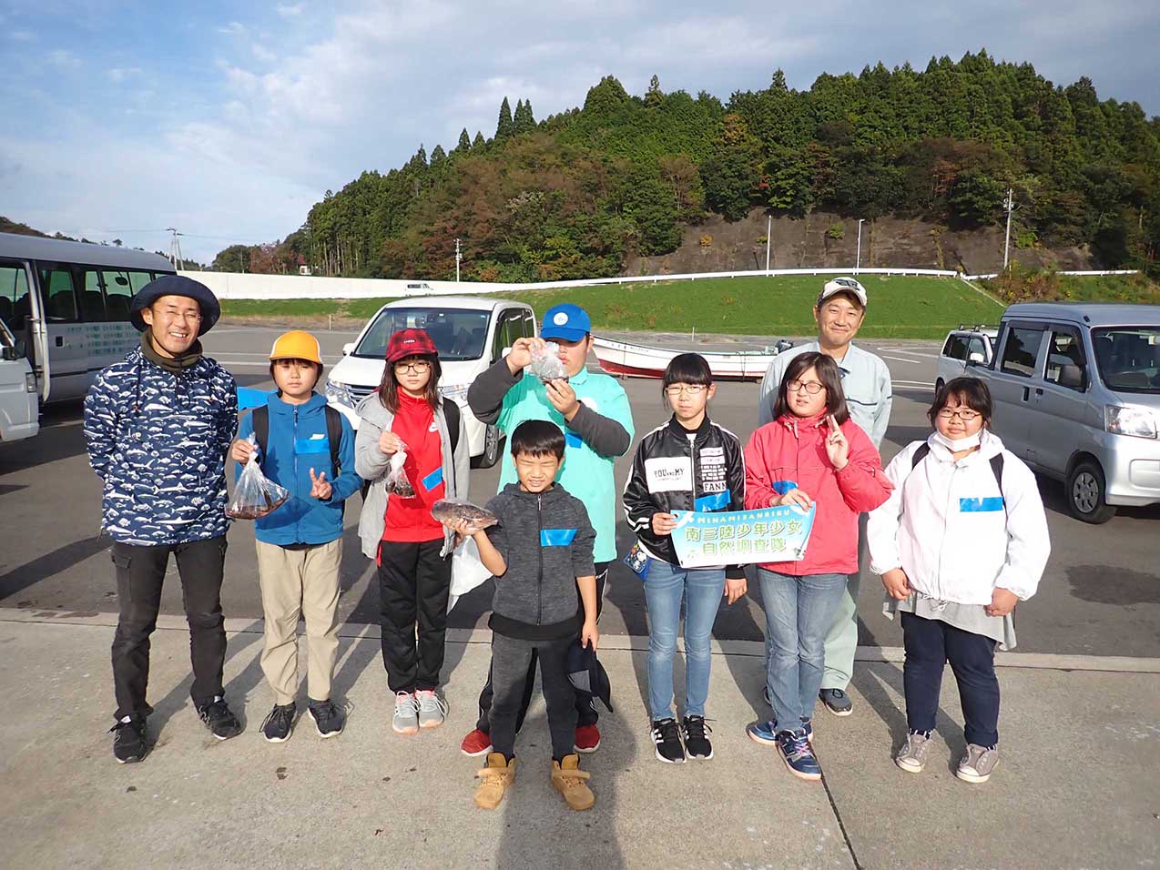 漁港で海釣り体験を行った子供たちが並んでいる集合写真