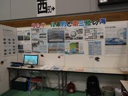 ラムサール条約と南三陸の海をテーマにした展示ブースの全景で、壁に多くのポスターが掲示され、テーブルの上にはパソコンやパンフレットが置かれている写真