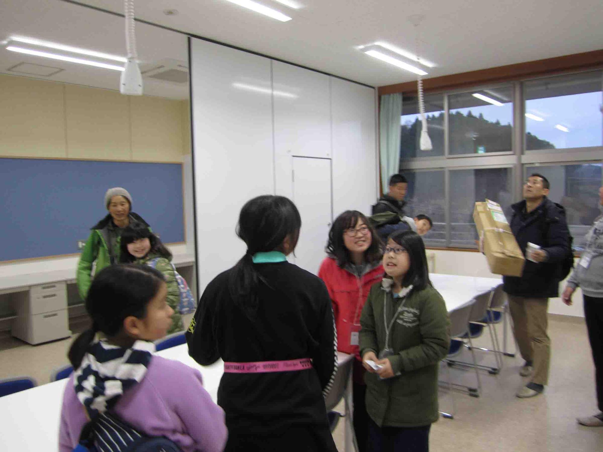 自然環境活用センターの室内で子どもたちが集まって談笑している写真