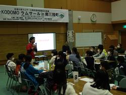 屋内講習会場で、スクリーンに投影された資料を見ながら真剣に講師の話を聞く大勢の子どもたちを写した写真