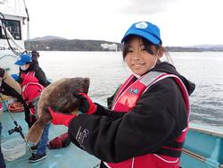 大きなヒラメを両手で持っている笑顔の女の子の写真