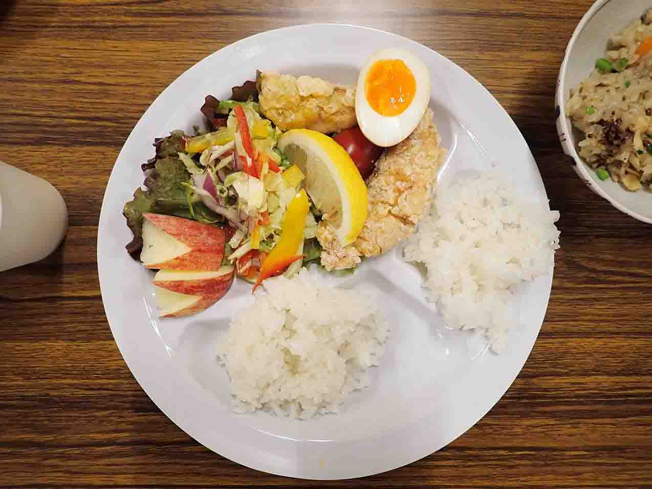 白いプレートに唐揚げ、ゆで卵、サラダ、ごはんが盛られている料理の写真