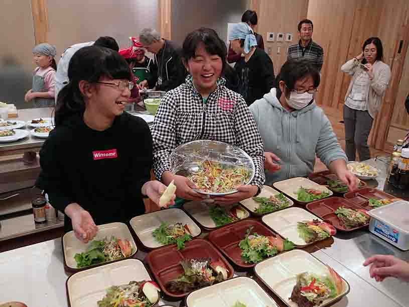 子どもたちが楽しそうに料理を盛り付けている様子の写真